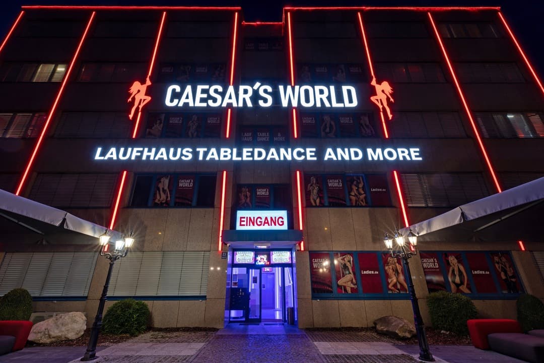 Die Fassade von Caesar’s World bei Nacht mit rotem Neon